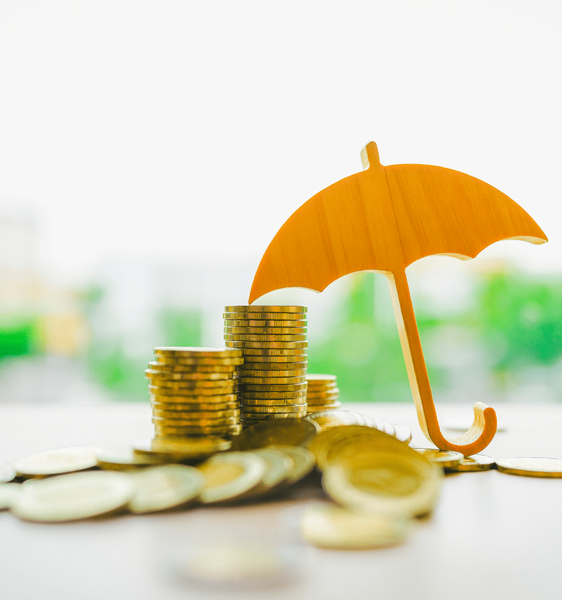 Coins stacked with umbrella protection
