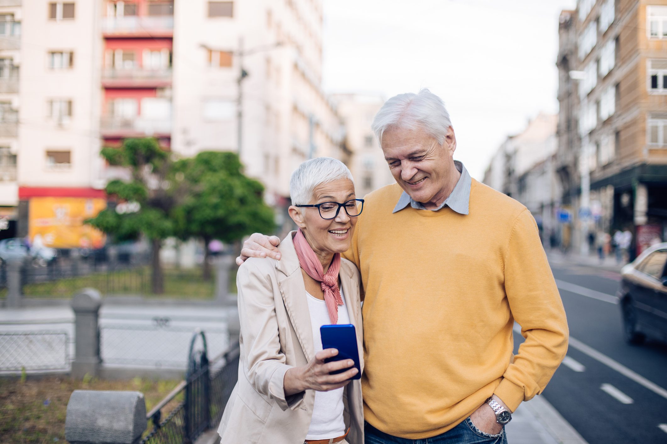 Elderly couple smiling at smartphone
