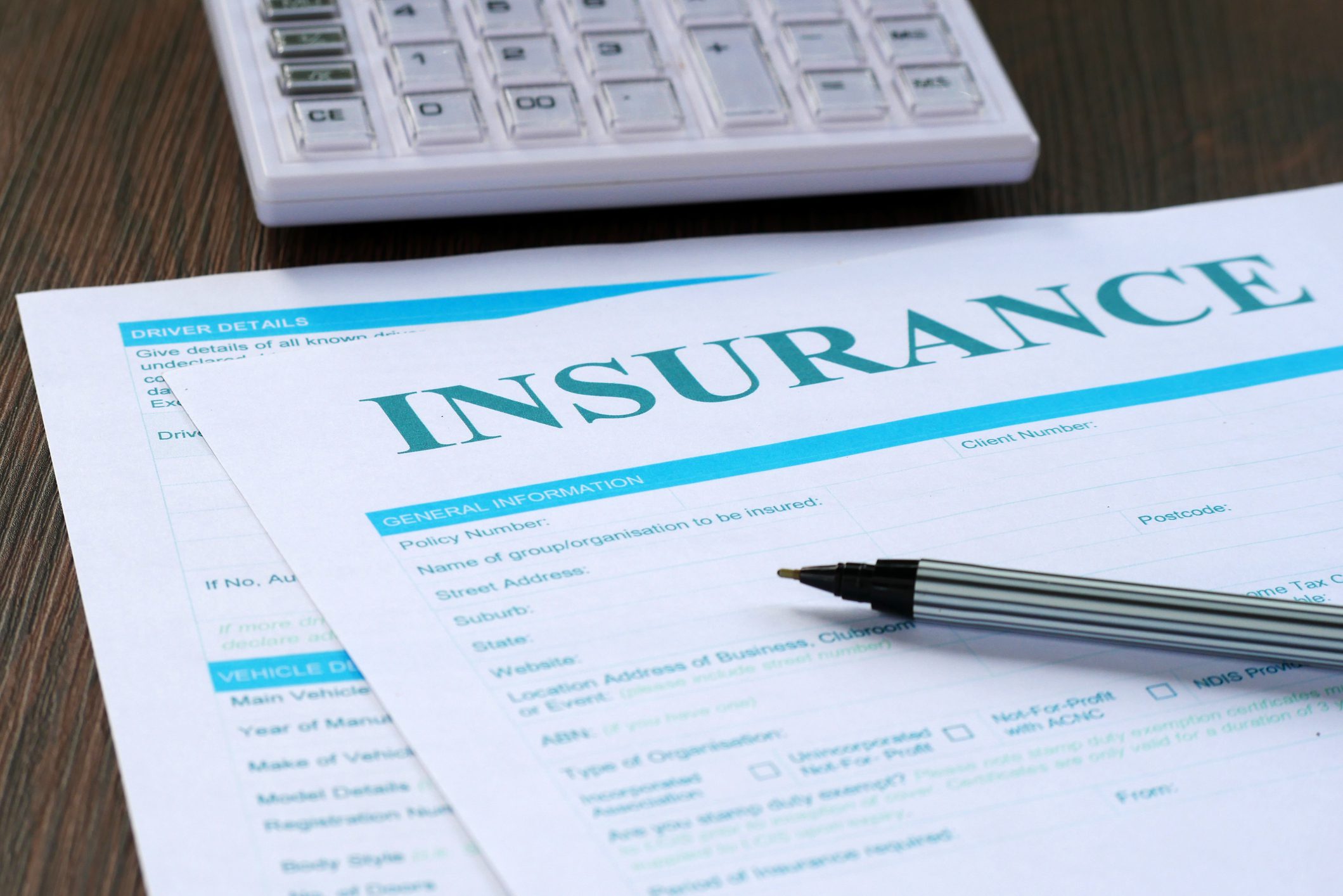Pen on insurance paperwork and calculator